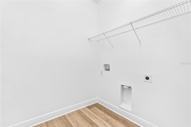 washroom with hookup for an electric dryer, baseboards, hookup for a washing machine, and light wood-style flooring