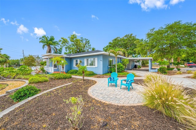 401 Whitcomb Blvd, Tarpon Springs, FL 34689 - rear view of property featuring a porch, stucco siding, and an attached carport