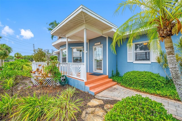 401 Whitcomb Blvd, Tarpon Springs, FL 34689 - doorway to property with stucco siding and a porch