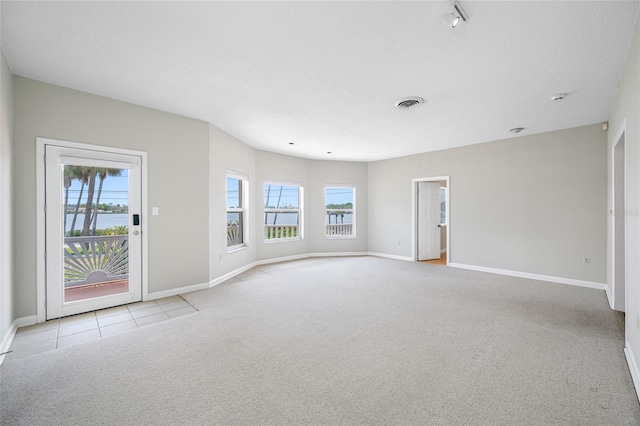 401 Whitcomb Blvd, Tarpon Springs, FL 34689 - unfurnished living room featuring plenty of natural light, carpet flooring, baseboards, and tile patterned flooring