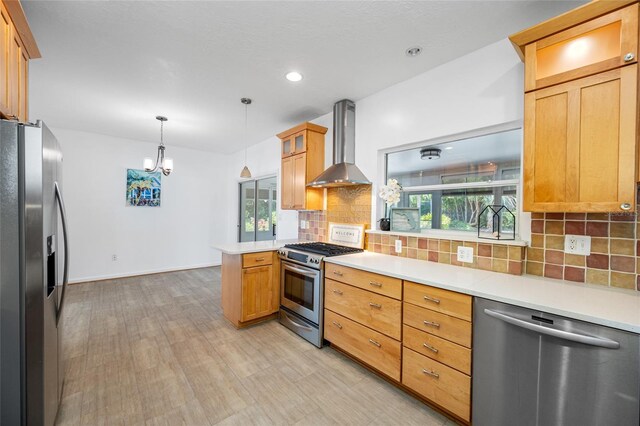401 Whitcomb Blvd, Tarpon Springs, FL 34689 - kitchen with stainless steel appliances, wall chimney exhaust hood, a peninsula, light countertops, and tasteful backsplash