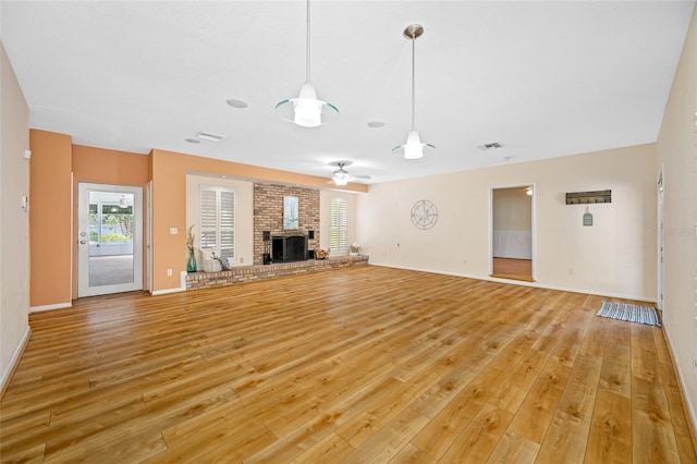 401 Whitcomb Blvd, Tarpon Springs, FL 34689 - unfurnished living room featuring light wood-style flooring, a fireplace, baseboards, and a ceiling fan