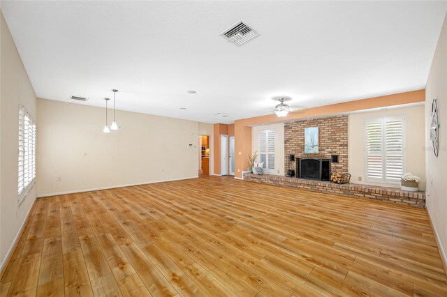401 Whitcomb Blvd, Tarpon Springs, FL 34689 - unfurnished living room featuring light wood-type flooring, a fireplace, a ceiling fan, and baseboards