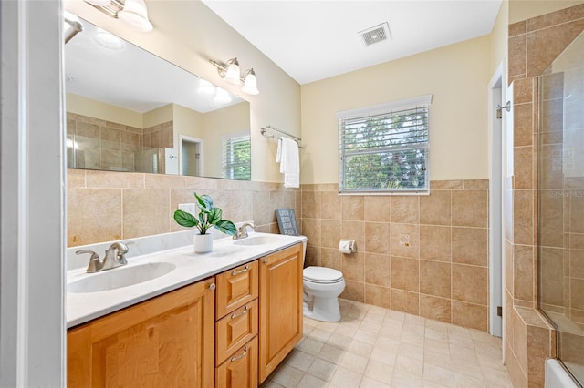 401 Whitcomb Blvd, Tarpon Springs, FL 34689 - bathroom with tile walls, tiled shower, toilet, tile patterned flooring, and double vanity