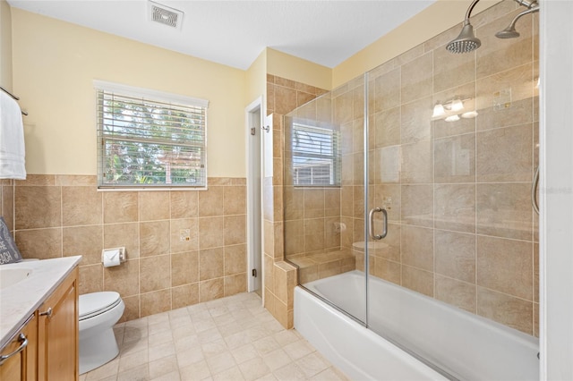 401 Whitcomb Blvd, Tarpon Springs, FL 34689 - bathroom with toilet, vanity, enclosed tub / shower combo, tile walls, and tile patterned flooring