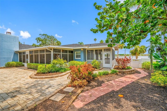 401 Whitcomb Blvd, Tarpon Springs, FL 34689 - back of property featuring a sunroom, fence, and a gate