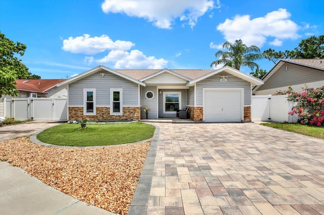 5875 Darren Ct N, Clearwater, FL 33760 - ranch-style house with a gate, decorative driveway, a garage, and stone siding