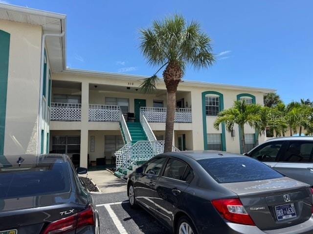 510 70th Ave, St Pete Beach, FL 33706 - view of property featuring stairs and uncovered parking