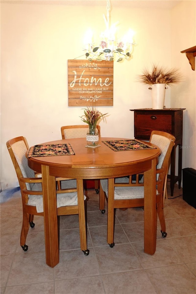 dining area with a chandelier and light tile patterned floors