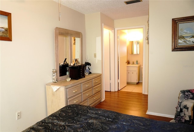 bedroom with wood finished floors and a textured ceiling