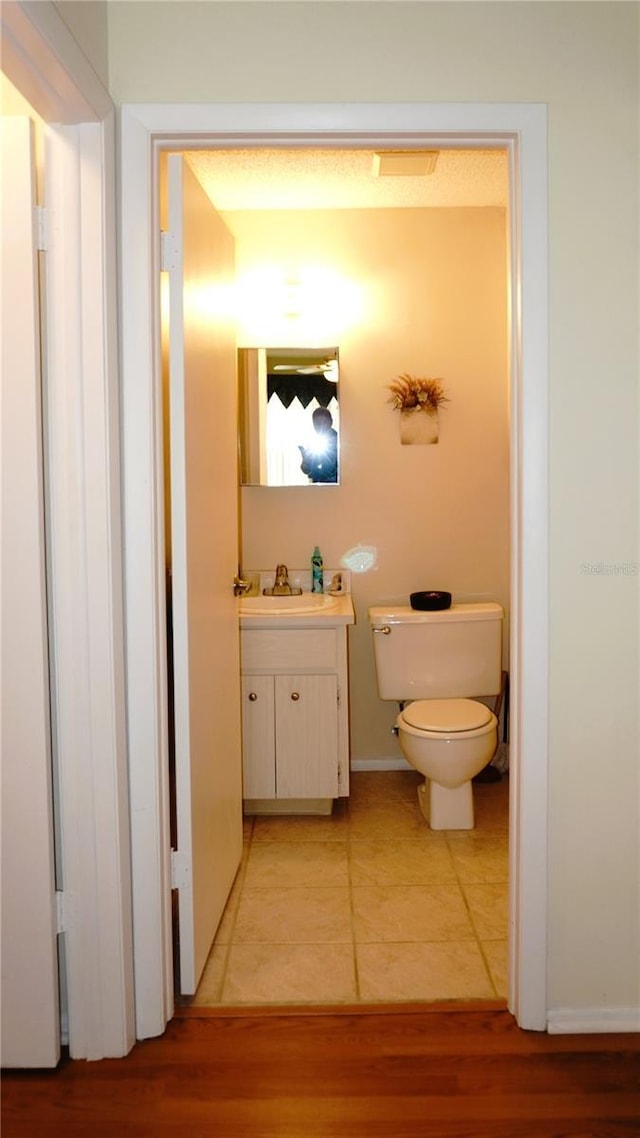 bathroom featuring vanity, toilet, and wood finished floors