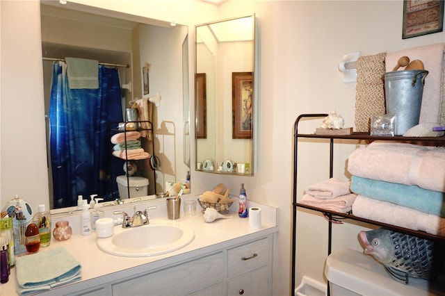 bathroom with toilet, vanity, and a shower with curtain