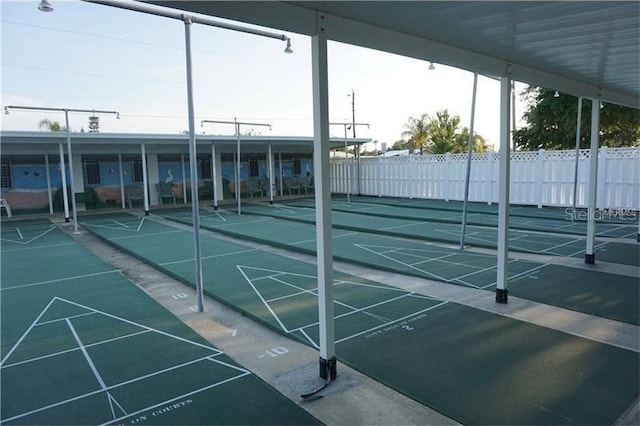 view of community with fence and shuffleboard