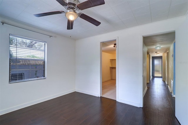 520 4th St NW, Largo, FL 33770 - unfurnished bedroom with dark wood-style flooring, baseboards, ceiling fan, and a spacious closet