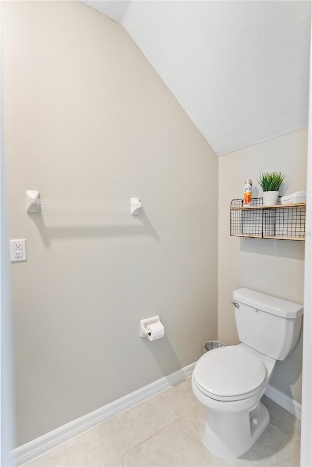9313 Lemon Drop Loop, Sun City Center, FL 33573 - bathroom featuring lofted ceiling, baseboards, toilet, and tile patterned flooring
