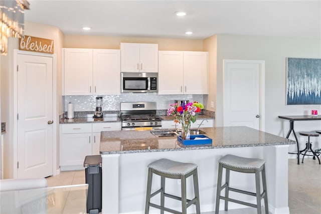 9313 Lemon Drop Loop, Sun City Center, FL 33573 - kitchen with appliances with stainless steel finishes, light tile patterned floors, a breakfast bar, decorative backsplash, and recessed lighting