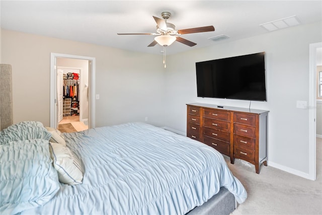 9313 Lemon Drop Loop, Sun City Center, FL 33573 - bedroom with a ceiling fan, light carpet, a walk in closet, and baseboards