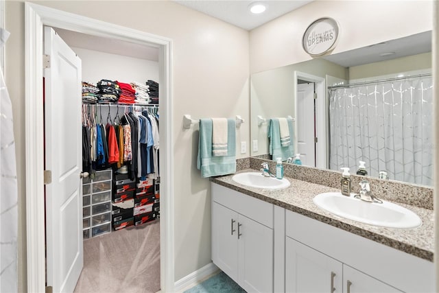 9313 Lemon Drop Loop, Sun City Center, FL 33573 - full bath with double vanity, a walk in closet, baseboards, and a shower with shower curtain
