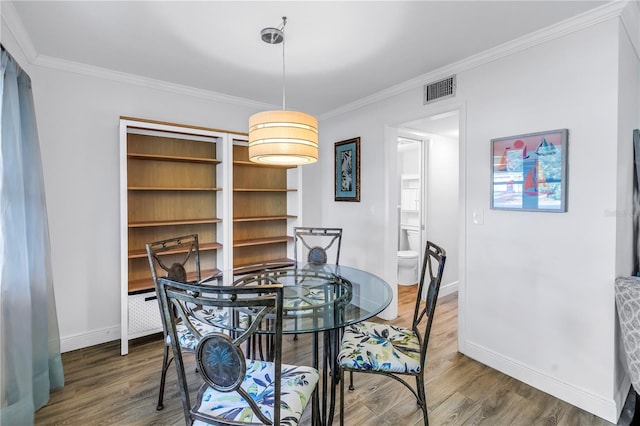 7801 11th St N Unit 104, Saint Petersburg, FL 33702 - dining room with baseboards, wood finished floors, and crown molding
