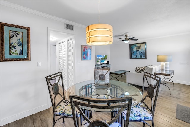 7801 11th St N Unit 104, Saint Petersburg, FL 33702 - dining space featuring baseboards, wood finished floors, ornamental molding, and a ceiling fan