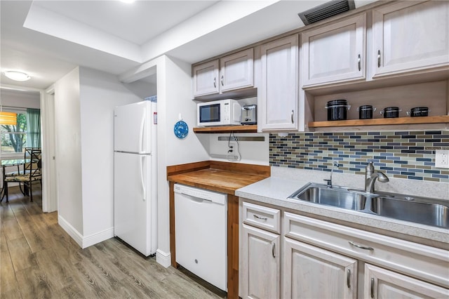 7801 11th St N Unit 104, Saint Petersburg, FL 33702 - kitchen with white appliances, open shelves, a sink, light wood-style flooring, and baseboards