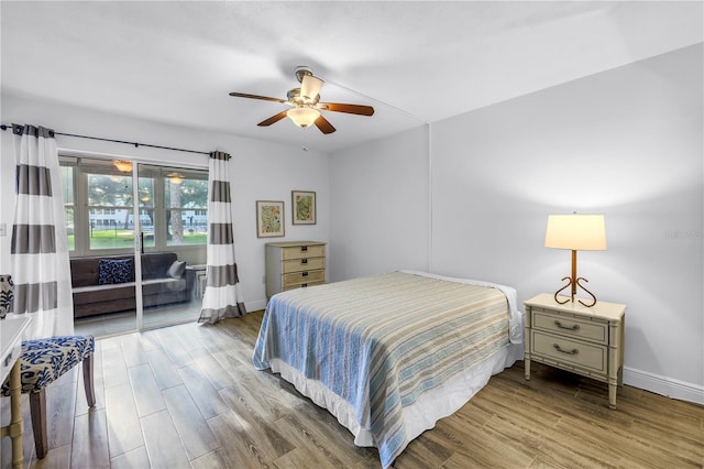 7801 11th St N Unit 104, Saint Petersburg, FL 33702 - bedroom featuring access to exterior, baseboards, wood finished floors, and ceiling fan