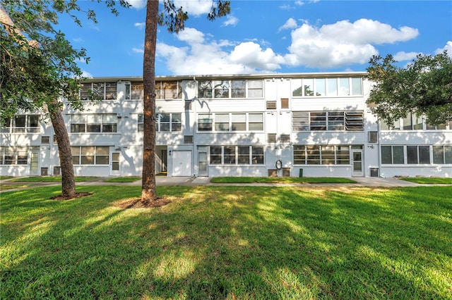 7801 11th St N Unit 104, Saint Petersburg, FL 33702 - rear view of property with a lawn and stucco siding