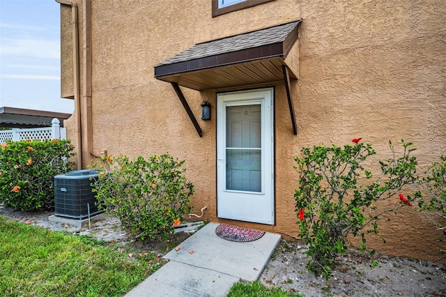 1864 Clearbrooke Dr, Clearwater, FL 33760 - doorway to property featuring central air condition unit and stucco siding