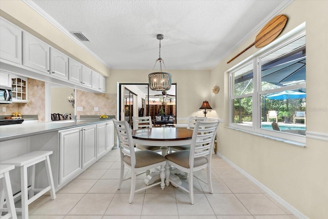535 Sandy Hook, Palm Harbor, FL 34683 - dining room with a chandelier, light tile patterned floors, a textured ceiling, baseboards, and crown molding