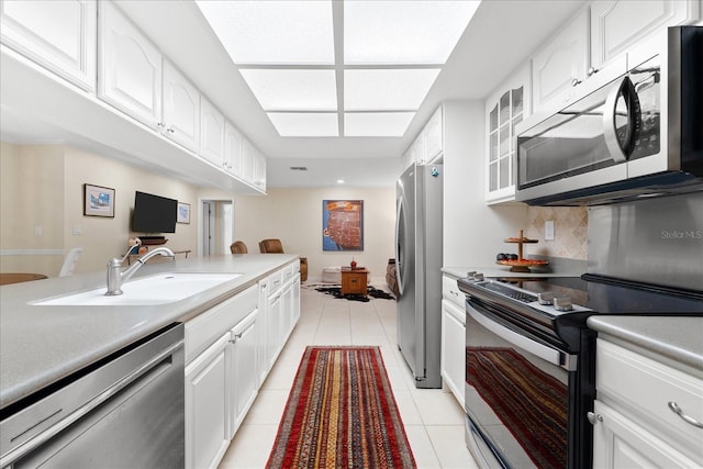 535 Sandy Hook, Palm Harbor, FL 34683 - kitchen featuring appliances with stainless steel finishes, light tile patterned flooring, white cabinets, and glass insert cabinets