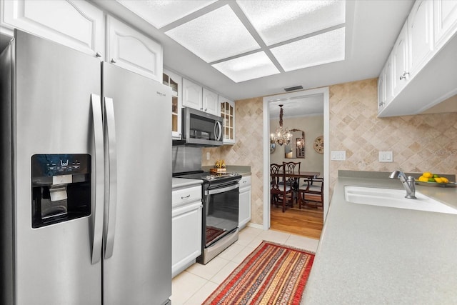 535 Sandy Hook, Palm Harbor, FL 34683 - kitchen with stainless steel appliances, white cabinetry, glass insert cabinets, light tile patterned floors, and a sink