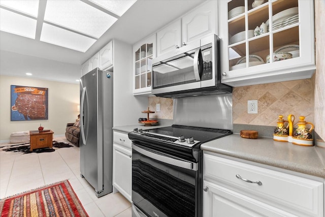 535 Sandy Hook, Palm Harbor, FL 34683 - kitchen featuring appliances with stainless steel finishes, glass insert cabinets, light tile patterned flooring, white cabinetry, and backsplash
