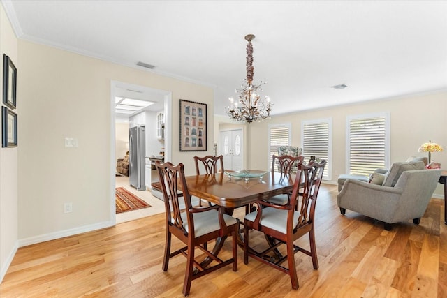 535 Sandy Hook, Palm Harbor, FL 34683 - dining room with light wood finished floors, a chandelier, crown molding, and baseboards
