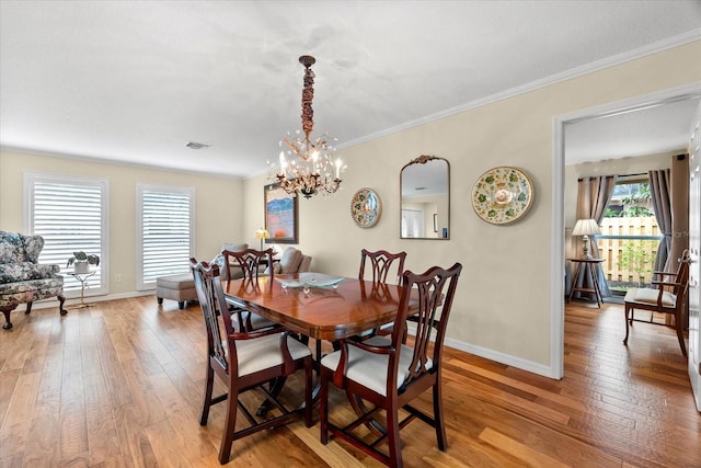535 Sandy Hook, Palm Harbor, FL 34683 - dining room with a chandelier, light wood-style floors, baseboards, and crown molding