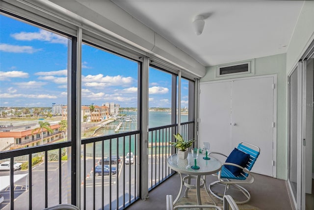 sunroom featuring a water view