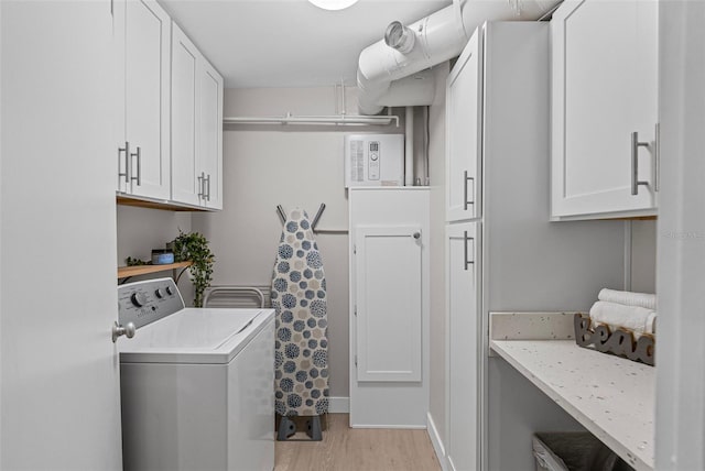 laundry area featuring independent washer and dryer, light wood finished floors, and cabinet space