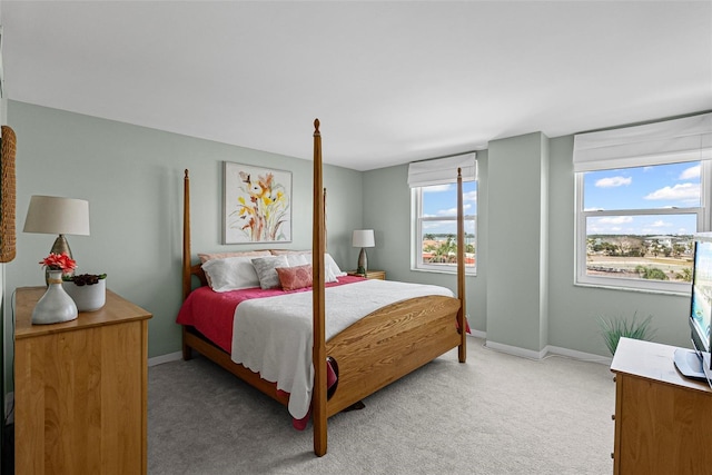 bedroom featuring light carpet and baseboards