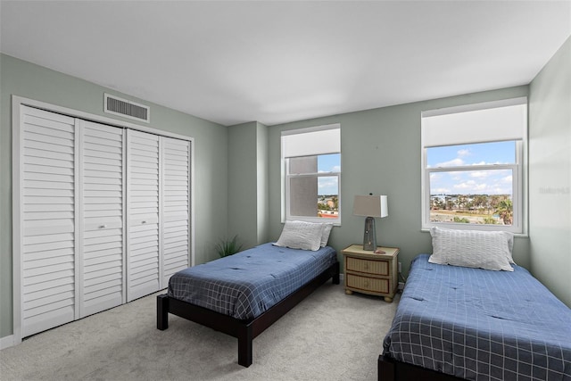 bedroom with light colored carpet and a closet