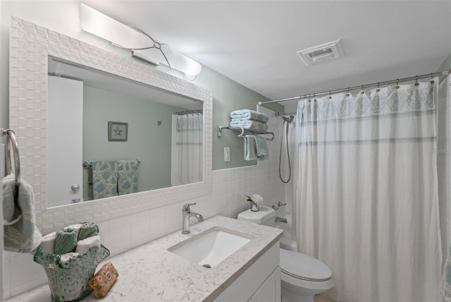 full bathroom featuring tile walls, vanity, toilet, and shower / tub combo