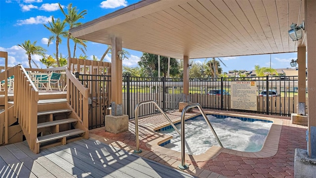 wooden deck with a hot tub and fence