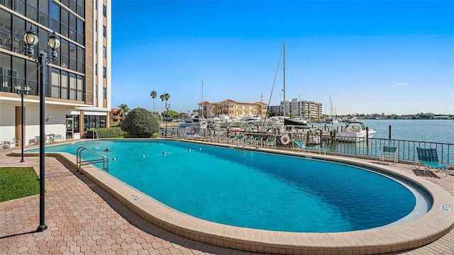 community pool with a water view and fence