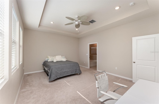 bedroom with a raised ceiling, recessed lighting, baseboards, light colored carpet, and a ceiling fan