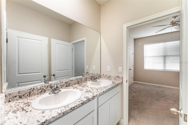 bathroom featuring double vanity, a ceiling fan, and baseboards