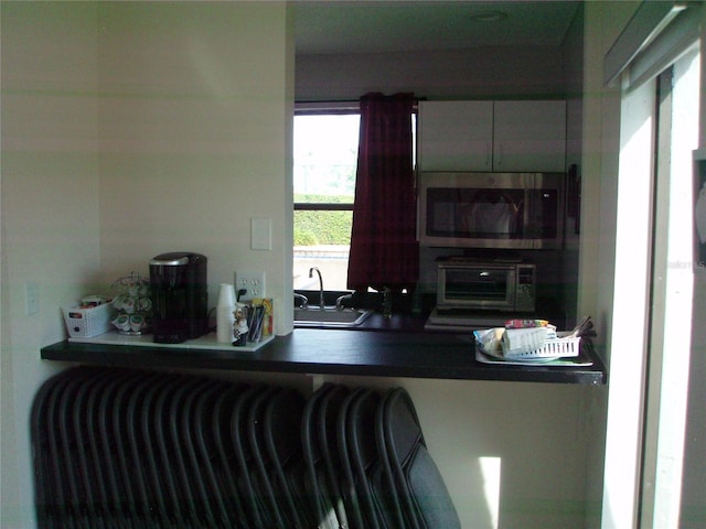 2980 Haines Bayshore Rd Unit 124, Clearwater, FL 33760 - kitchen featuring stainless steel microwave, a sink, and dark countertops