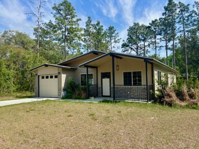 6906 W Barbara Ann Ln, Homosassa, FL 34446 - view of front of home with driveway, an attached garage, and a front lawn