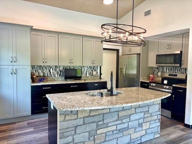 6906 W Barbara Ann Ln, Homosassa, FL 34446 - kitchen featuring stainless steel appliances, a sink, wood finished floors, an island with sink, and hanging light fixtures