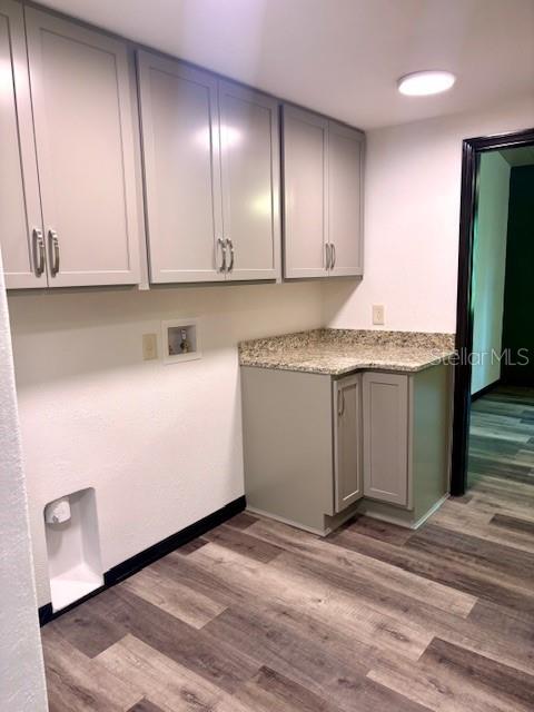 6906 W Barbara Ann Ln, Homosassa, FL 34446 - laundry area featuring cabinet space, hookup for a washing machine, wood finished floors, and baseboards
