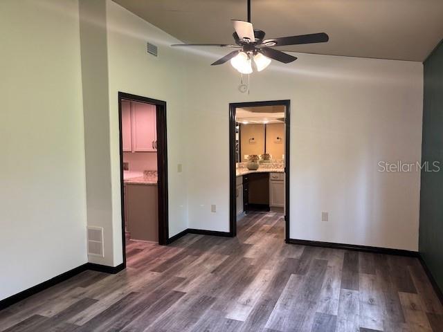 6906 W Barbara Ann Ln, Homosassa, FL 34446 - empty room featuring a ceiling fan, dark wood-style floors, and baseboards