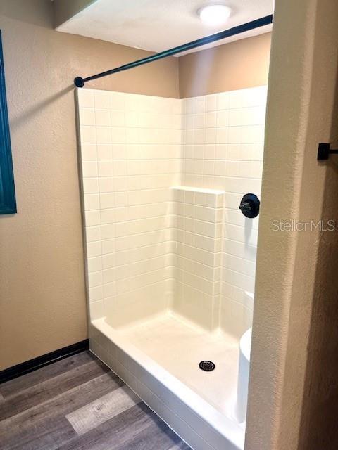 6906 W Barbara Ann Ln, Homosassa, FL 34446 - bathroom featuring a shower stall, wood finished floors, and baseboards