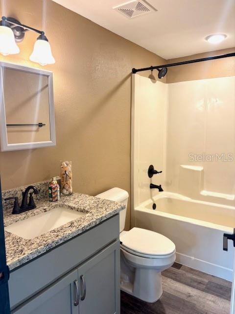 6906 W Barbara Ann Ln, Homosassa, FL 34446 - full bath with wood finished floors, vanity, shower / bath combination, and toilet